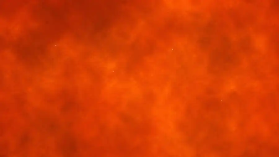 A second microscope view with particles on a warmer, orange background